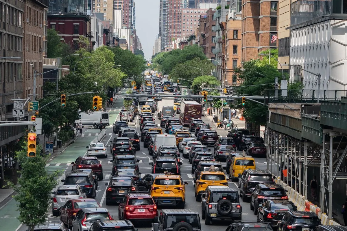 New York City midtown avenue with yellow taxis and heavy rush hour traffic between tall buildings